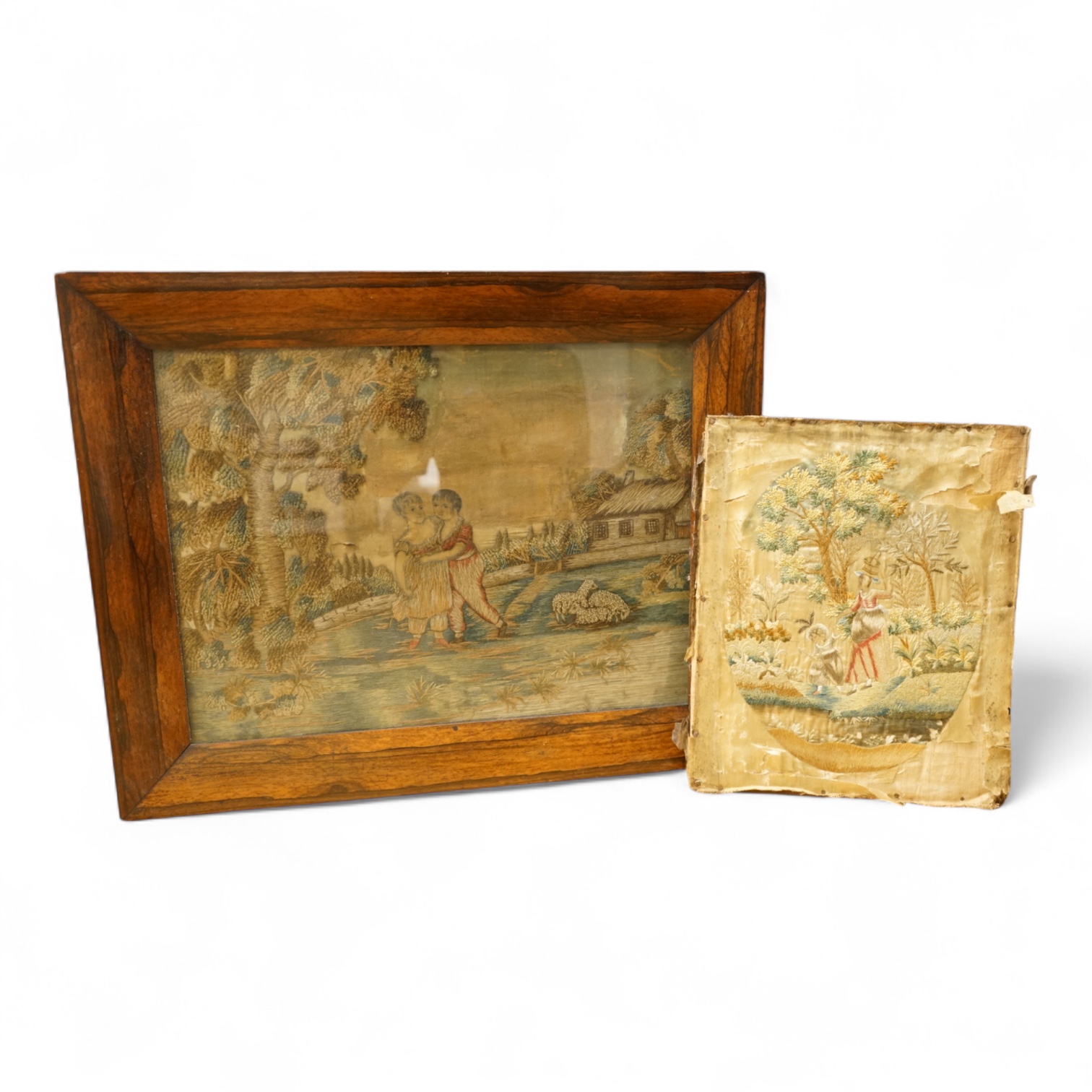 Two early 19th century embroidered silk tapestries depicting figures in landscapes, one framed, largest 52cm high